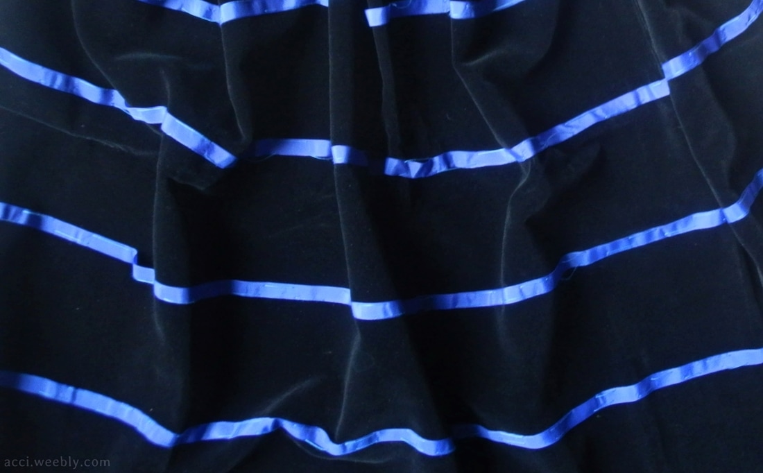 Panneggio del velluto nero con strisce blu usato per l'abito della modella.